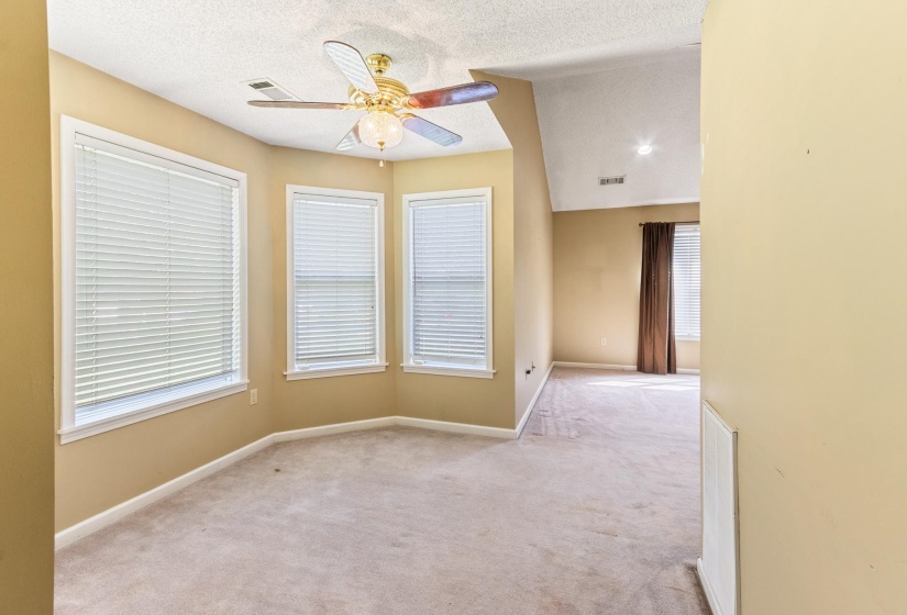 Carpeted empty room featuring a textured ceiling and a ceiling fan