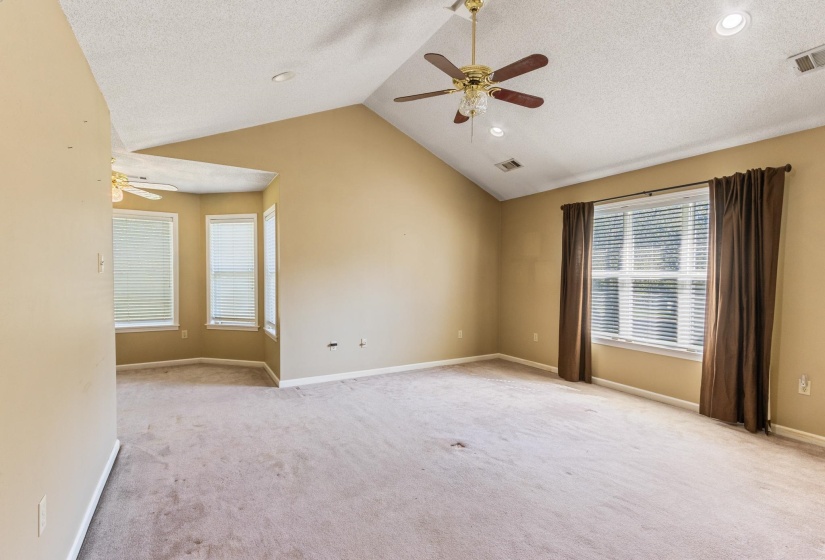 Empty room with lofted ceiling, light colored carpet, ceiling fan, a textured/high ceiling, and recessed lighting