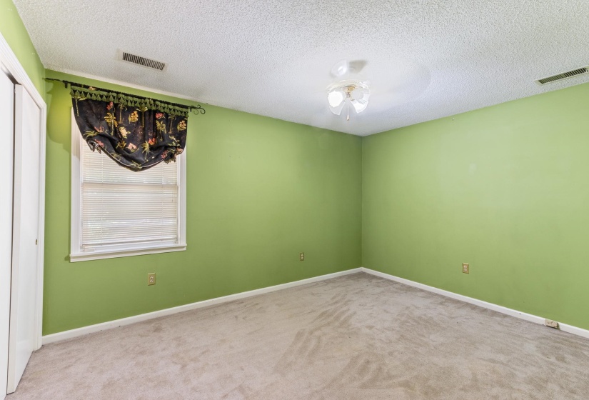 Unfurnished room with a textured ceiling, carpet, and ceiling fan