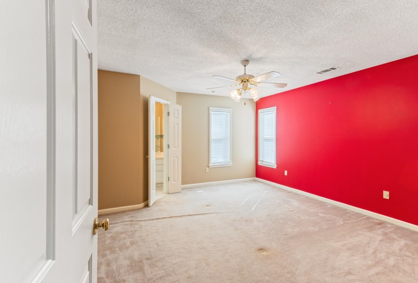 Empty room with carpet, ceiling fan, and a textured ceiling