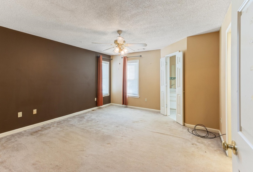 Carpeted spare room featuring a textured ceiling and ceiling fan