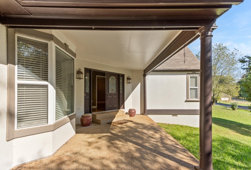 Property entrance with a yard, covered porch, crawl space, and stucco siding