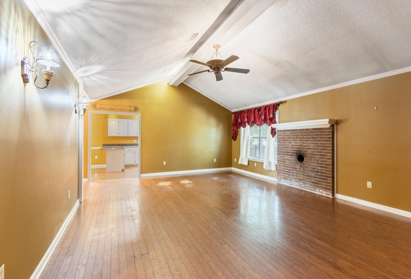 Unfurnished living room with light wood finished floors, a textured ceiling, and ceiling fan