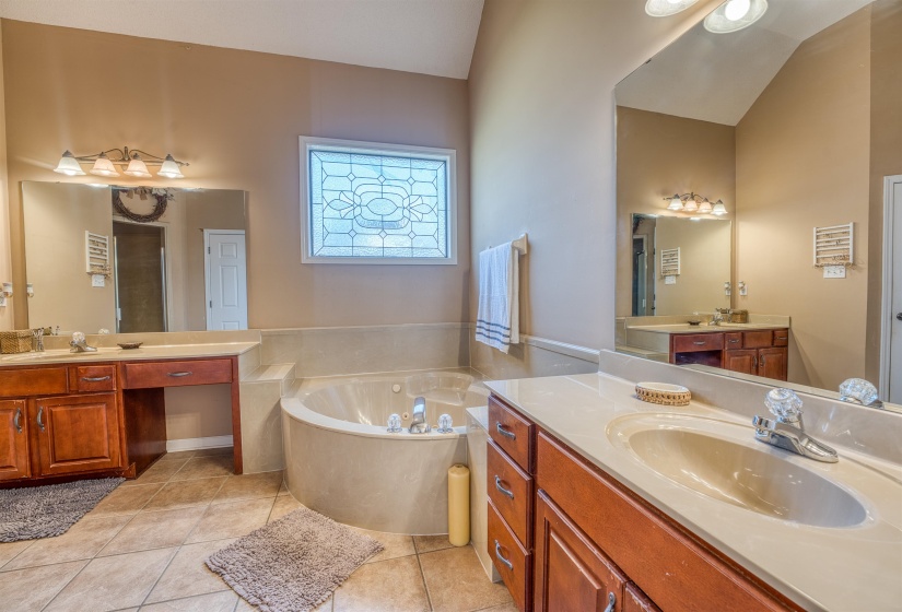 Full bathroom with tile patterned flooring, a sink, two vanities, and a bath
