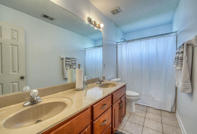 Full bathroom featuring tile patterned floors, a sink, and visible vents