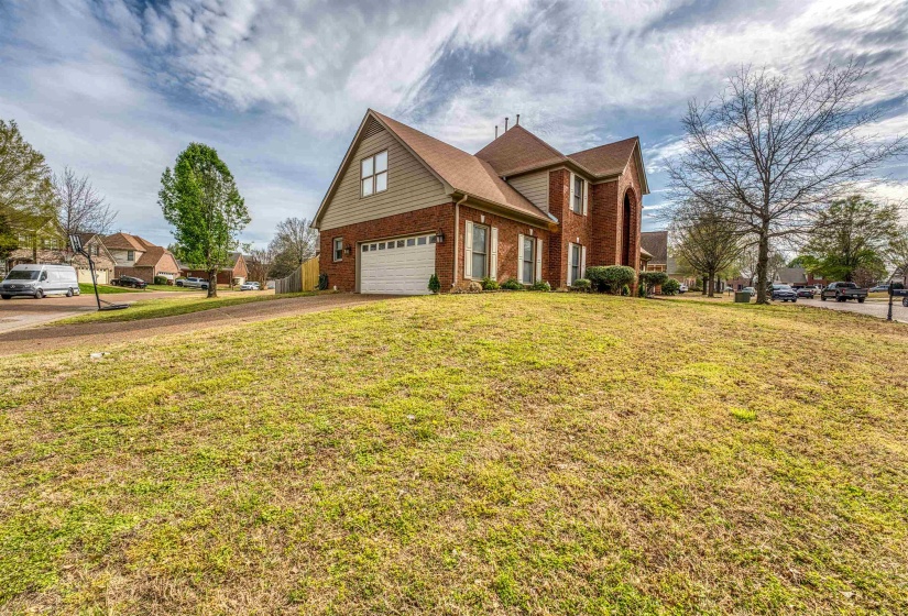 View of front of home with a front lawn, an attached garage, brick siding, and concrete driveway