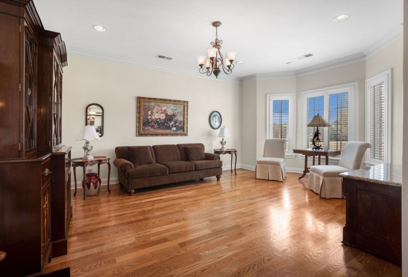 Living area featuring ornamental molding, visible vents, and light wood-style floors
