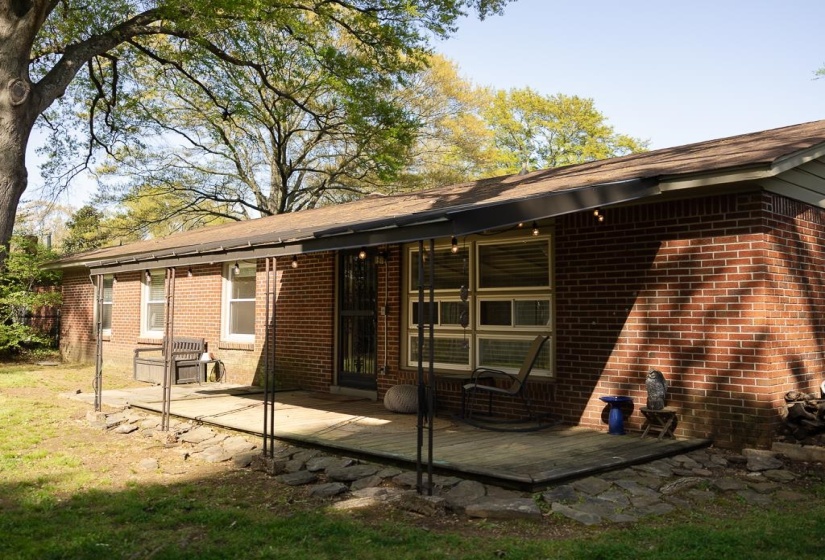 Rear view of house with brick siding and a patio