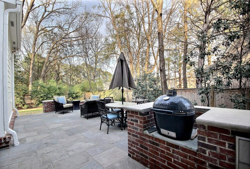 View of patio with exterior kitchen, fence, a grill, and outdoor dining space