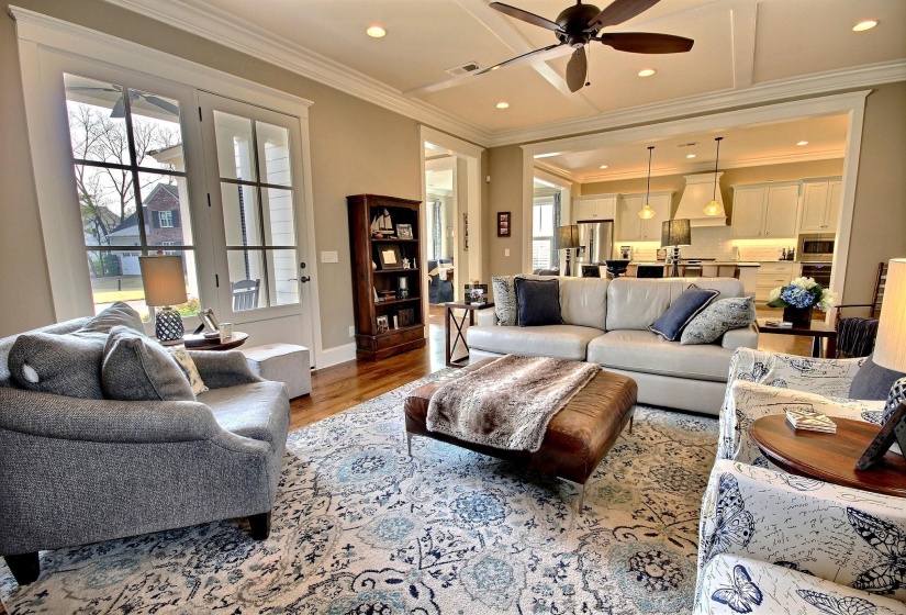 Living room with recessed lighting, ornamental molding, ceiling fan, and wood finished floors