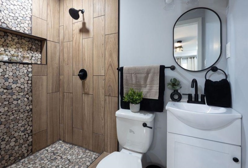 Bathroom with toilet, vanity, and a tile shower