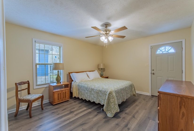 Bedroom featuring multiple windows, wood finished floors, baseboards, and a textured ceiling