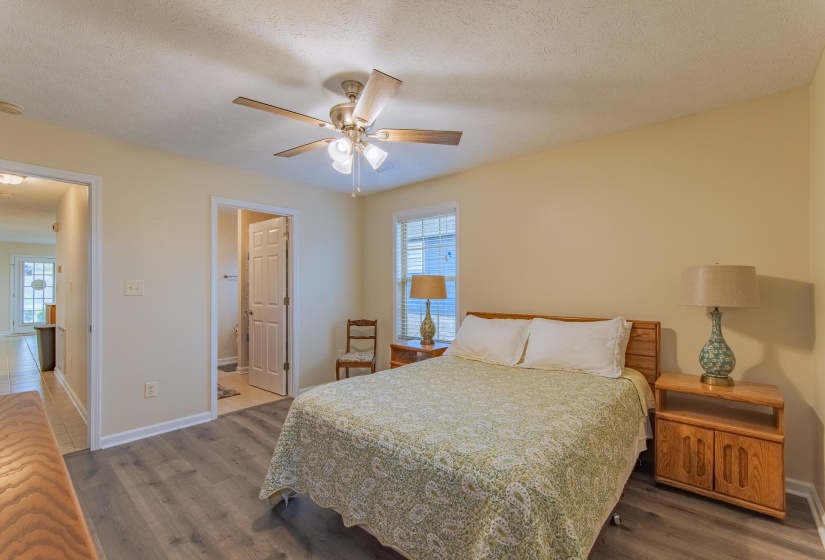 Bedroom featuring baseboards, wood finished floors, and multiple windows