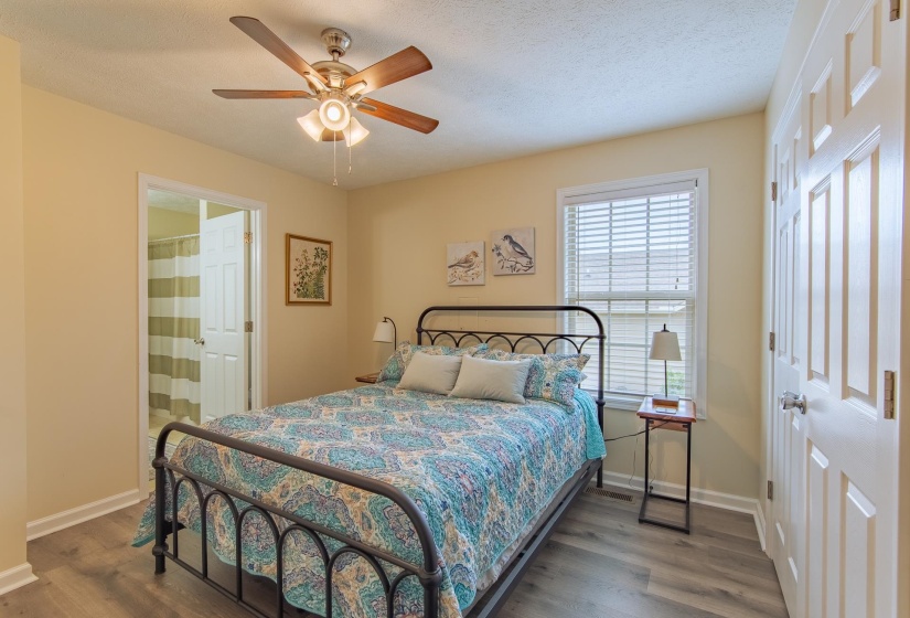 Bedroom featuring a textured ceiling, baseboards, ceiling fan, and wood finished floors