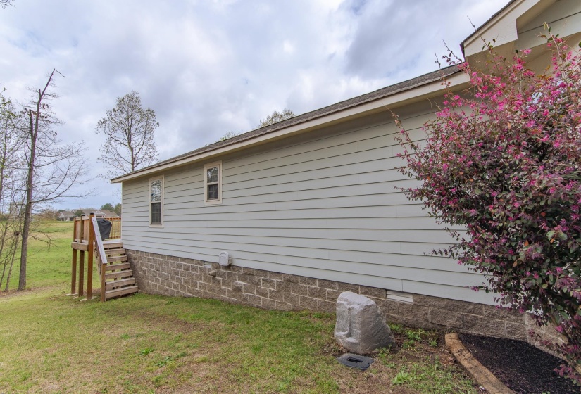 View of home's exterior with stairs and a lawn