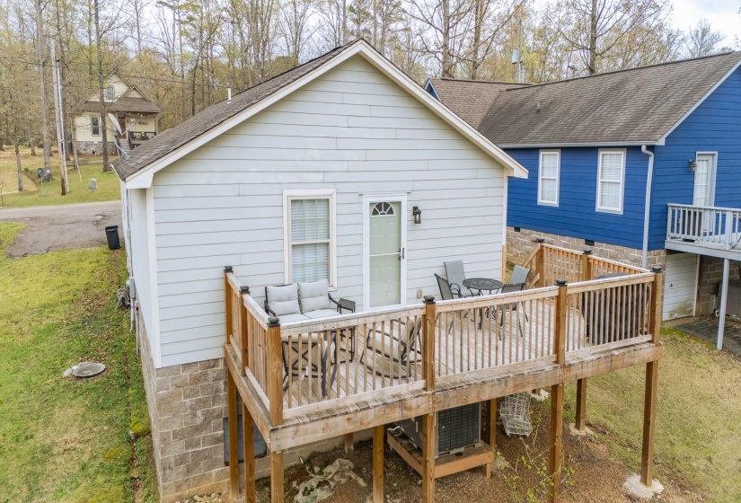 Back of house with a yard, a deck, and roof with shingles