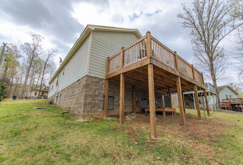 Back of property with a yard and a wooden deck