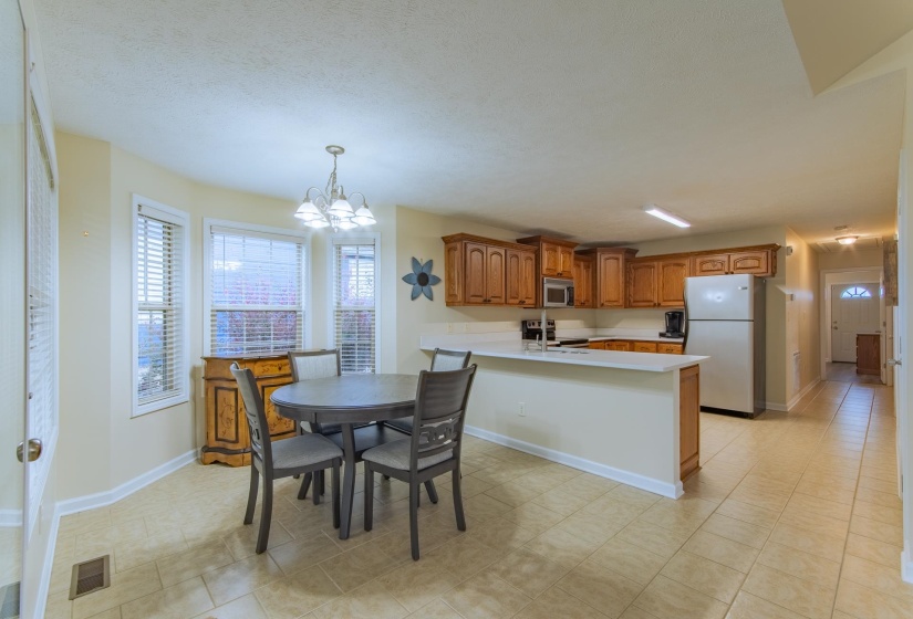 Dining room with a textured ceiling, visible vents, baseboards, and an inviting chandelier