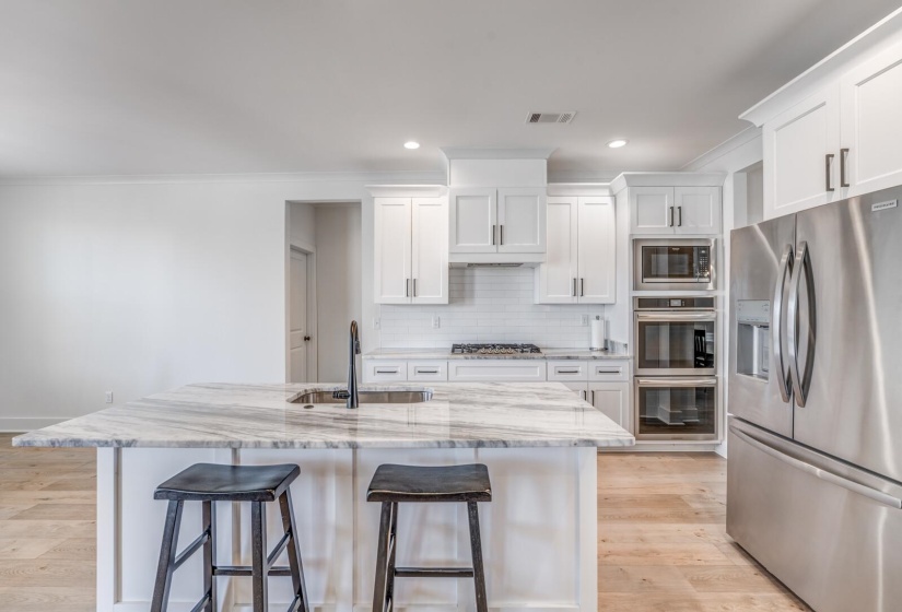 Kitchen featuring visible vents, a kitchen breakfast bar, a sink, and stainless steel appliances