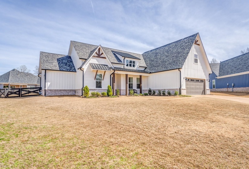 Modern farmhouse style home with fence, a garage, a front lawn, board and batten siding, and driveway