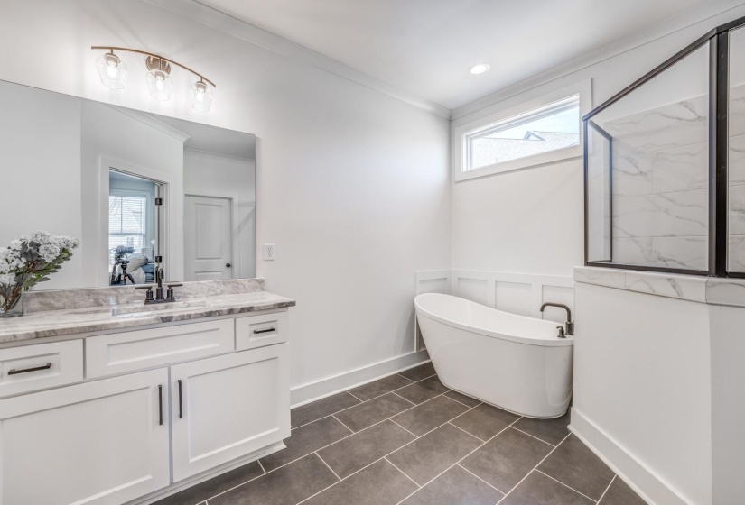 Full bath with a soaking tub, ornamental molding, a marble finish shower, tile patterned floors, and vanity