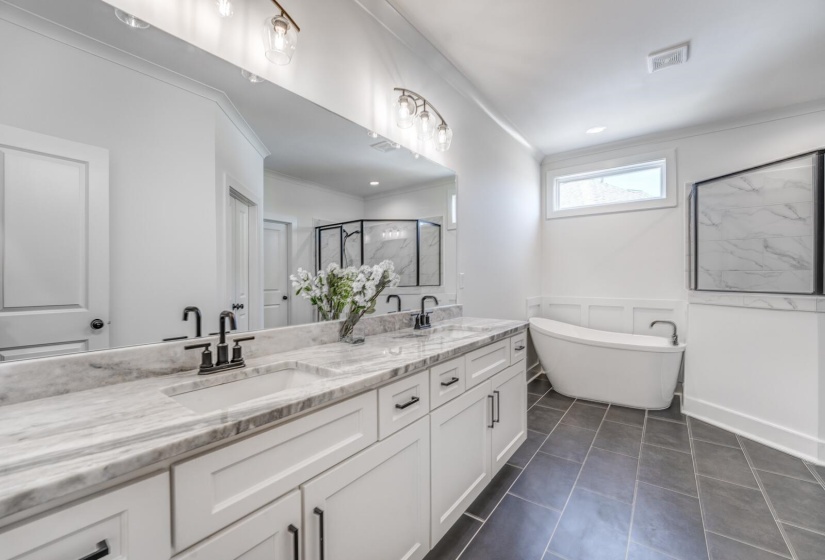 Bathroom with double vanity, ornamental molding, a sink, and a stall shower