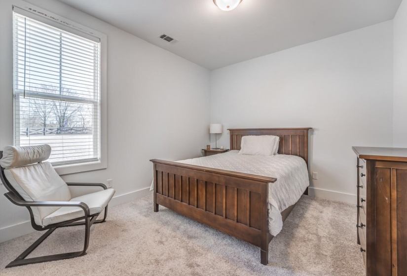 Bedroom featuring baseboards, visible vents, and carpet floors
