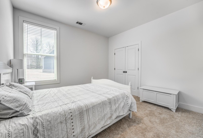 Bedroom with light colored carpet, visible vents, a closet, and baseboards