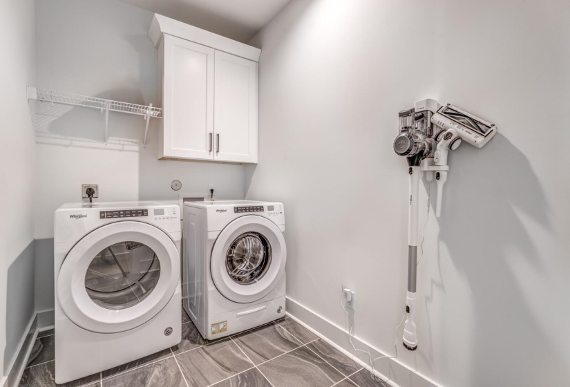 Laundry area with washing machine and clothes dryer, cabinet space, and baseboards