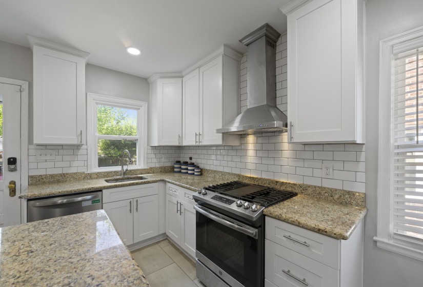 Prep island, gas cooking, venthood, subway tile backsplash, and who doesn't love a window over the kitchen sink!?
