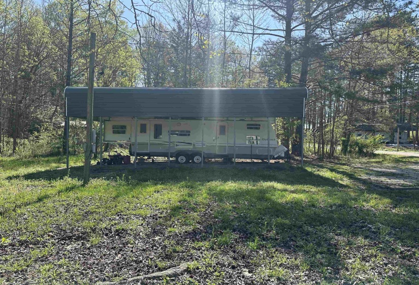 View of front facade with a front yard and a detached carport