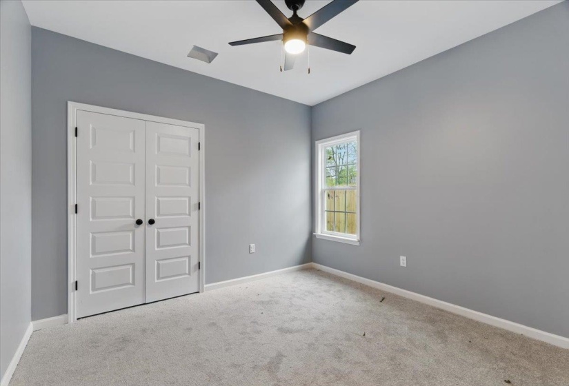 Unfurnished bedroom with a ceiling fan, carpet floors, baseboards, and a closet