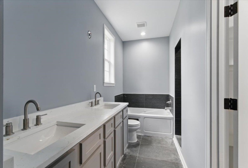 Full bath with visible vents, toilet, a sink, and a garden tub