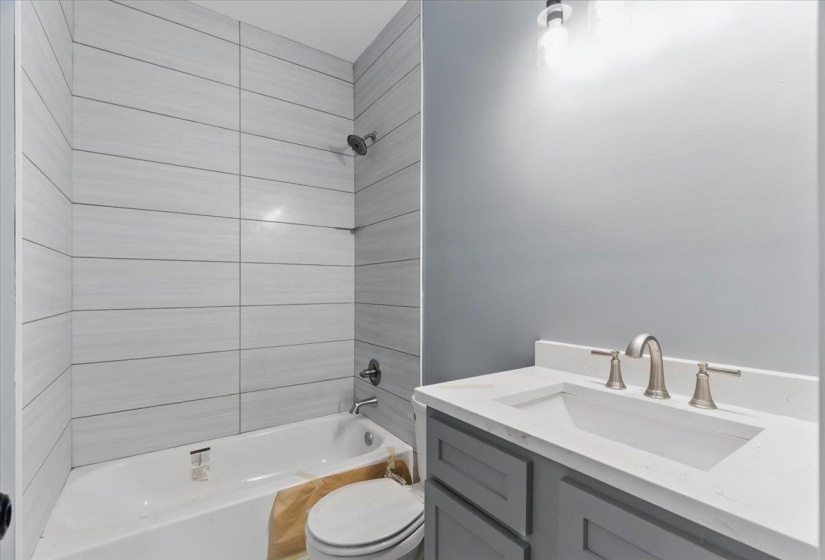 Full bathroom featuring toilet, shower / bath combination, and vanity