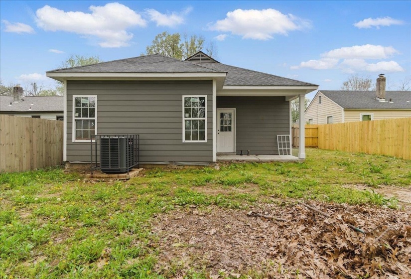 Rear view of property with a fenced backyard, a lawn, central AC, and a patio