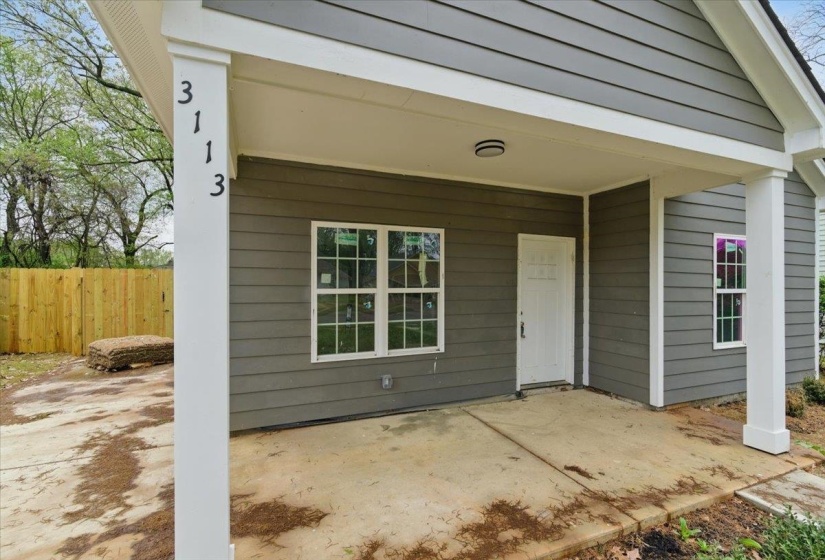 View of exterior entry featuring fence and a patio area