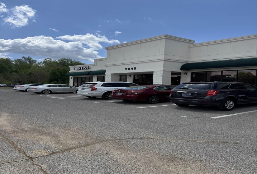 View of building exterior with uncovered parking