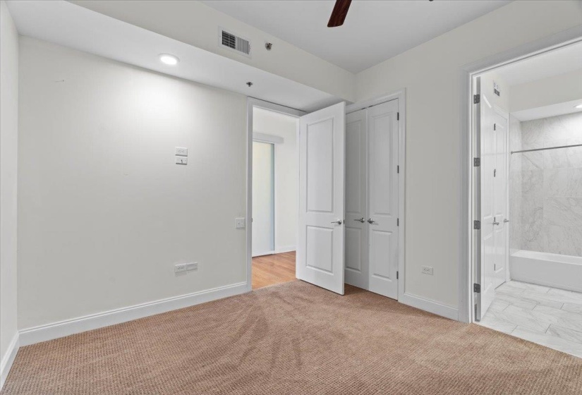 Unfurnished bedroom featuring carpet, ensuite bath, visible vents, recessed lighting, and baseboards