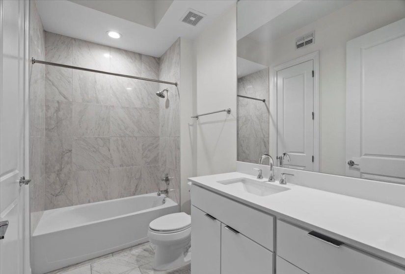 Full bathroom featuring visible vents, toilet, marble finish floor, and  shower combination