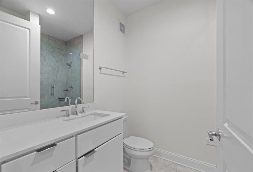 Full bath with vanity, visible vents, toilet, a stall shower, and baseboards