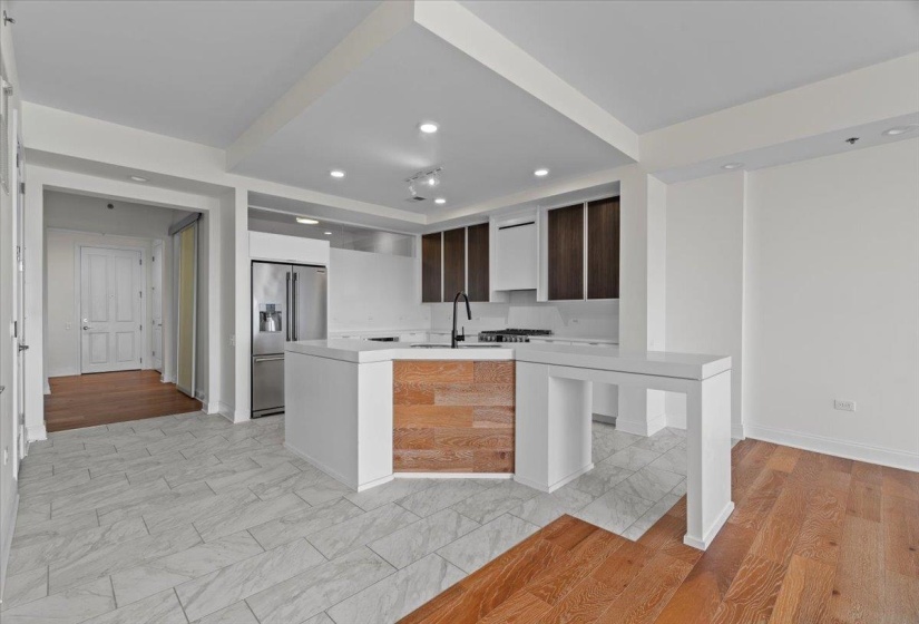 Kitchen featuring high end fridge, recessed lighting, light countertops, modern cabinets, and a sink