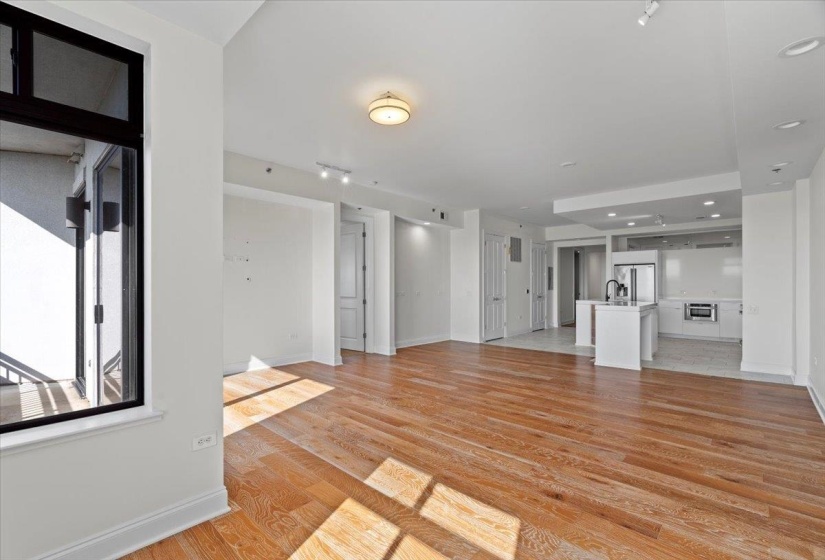 Unfurnished living room with a sink, light wood-type flooring, and baseboards