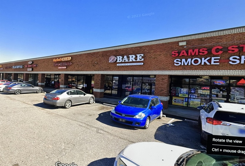 View of building exterior featuring uncovered parking