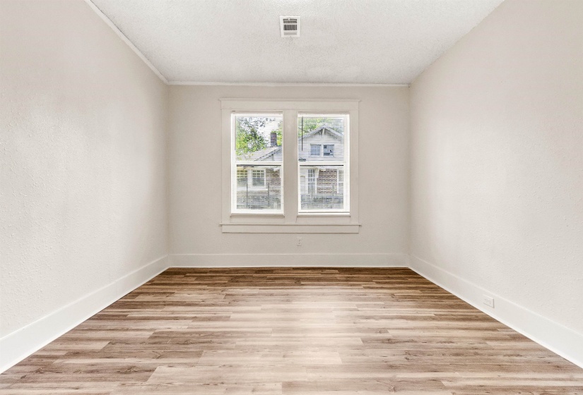 Spare room featuring light wood-type flooring, baseboards, and visible vents