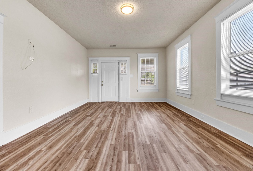 Entryway featuring light wood-style flooring, a textured ceiling, baseboards, and visible vents