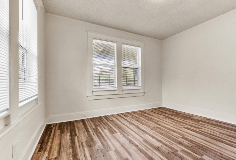 Unfurnished room with baseboards, a textured ceiling, and wood finished floors