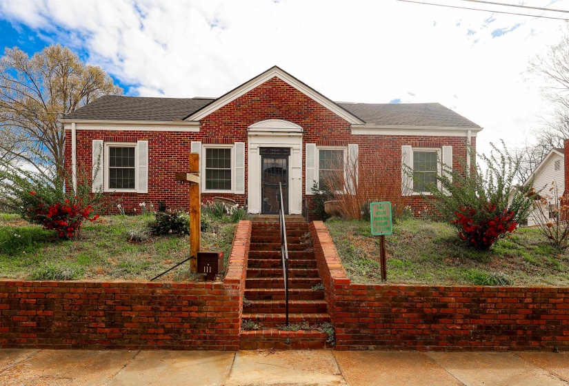 Bungalow-style home featuring a shingled roof and brick siding