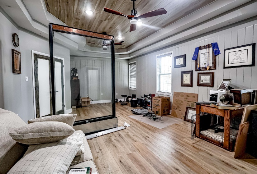 Bedroom with a raised ceiling, wood finished floors, and wood ceiling