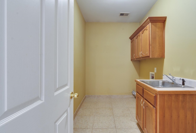Laundry area with hookup for a washing machine, cabinet space, and light tile patterned flooring