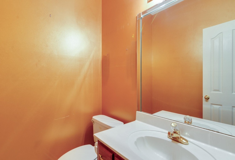 Half bathroom with vanity and toilet